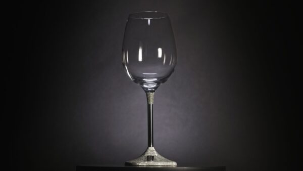 Close-up of a single silver wine goblet, finely engraved with grapevine and leaf motifs