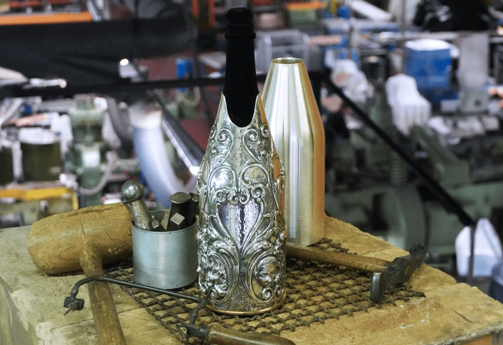 Artisan crafting metal to create a champagne